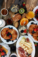 breakfast on table with waffles, croissants, coffe and juice.