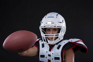 Naklejka premium Portrait of sexy attractive young girl in a sports outfit for rugby with the helmet strongly looking forward standing on black background