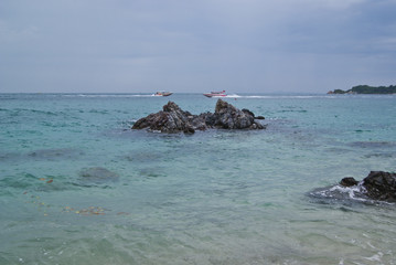 Seascape - azure clear water near the stony shore. Tropical paradise