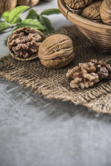 Walnuts in wooden bowl. Whole walnut on table