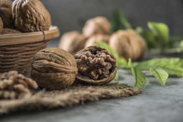 Walnuts in wooden bowl. Whole walnut on table