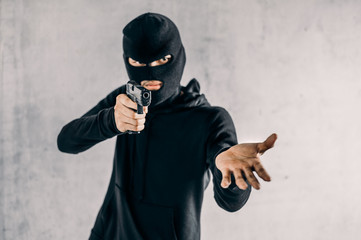 Robber with a gun robbing intimidate.Crime and robbery concept.