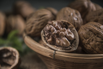 Walnuts in wooden bowl. Whole walnut on table