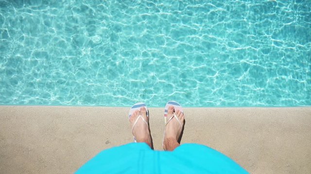 Above view on male foots near pool. Summertime vacation