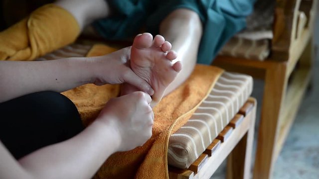 Thai foot massage under foot, using wooden tool