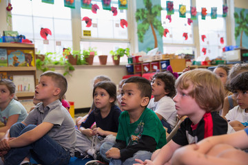 Students listening to their teacher in a kindergarten classroom.