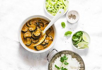 Roasted eggplant curry sauce and rice on a light background, top view. Indian vegetarian cuisine....