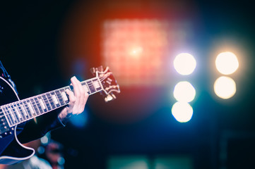 man playing guitar on a stage musical concert close-up view.guitarist plays.