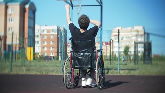 Disabled man plays basketball from his wheelchair, On open air