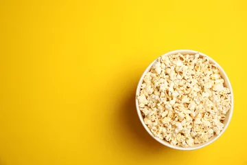 Rolgordijnen Paper bucket with tasty fresh popcorn on color background, top view © New Africa