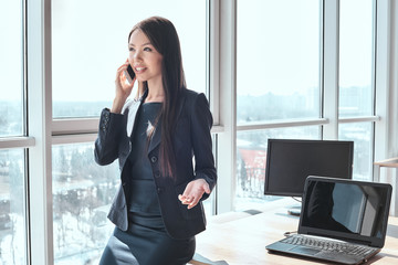 Businessperson at office alone standing talking on smartphone jo