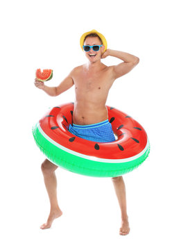 Shirtless man with inflatable ring and watermelon on white background