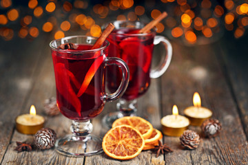 Mulled wine in glasses with spices on wooden table