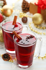 Mulled wine in glasses with spices on wooden table