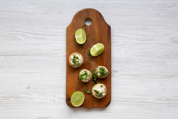 Mushroom and chicken puree with lime on rustic wooden board, top view. White wooden surface. Flat lay, overhead.