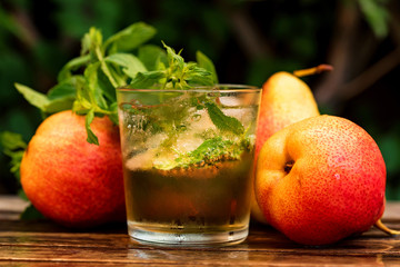 Ripe pears and pear drink on a wooden table