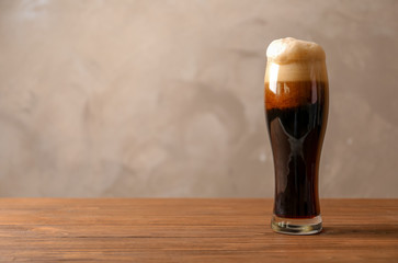 Glass of cold dark beer on wooden table