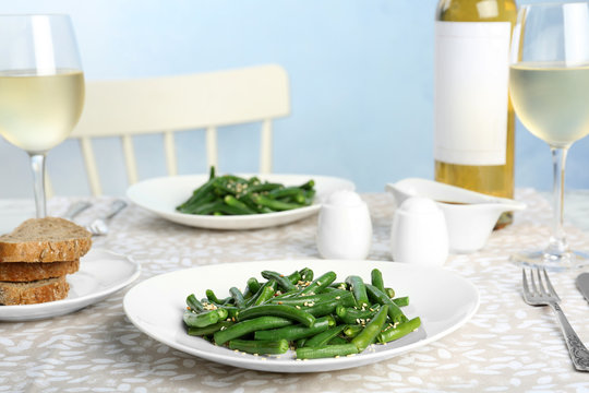 Tasty green beans with sesame seeds served for dinner on table