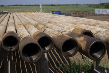 Oil Drill pipe. Rusty drill pipes were drilled in the well section. Downhole drilling rig. Laying the pipe on the deck. View of the shell of drill pipes laid in courtyard of the oil and gas warehouse.