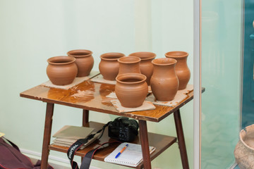 Pottery at the table after master-class, with camera and notebook