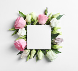 Beautiful Eustoma flowers and card on light background