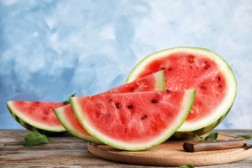 Wooden board with juicy watermelon slices on table