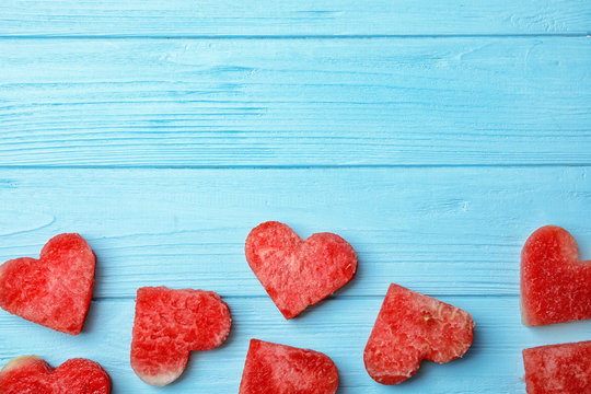 Flat lay composition with heart shaped watermelon slices on wooden background