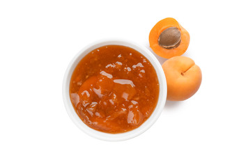 Jar with delicious apricot jam and fruit on white background