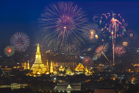 Travel to Bangkok, Thailand. Golden pagoda in Wat Arun temple at night with celebrating firework in the sky. Wat Arun at sunset is a most favorite scene of travellers.