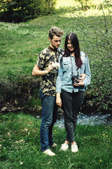 stylish beautiful couple camping smiling,  with analog photo camera in spring sunny mountains