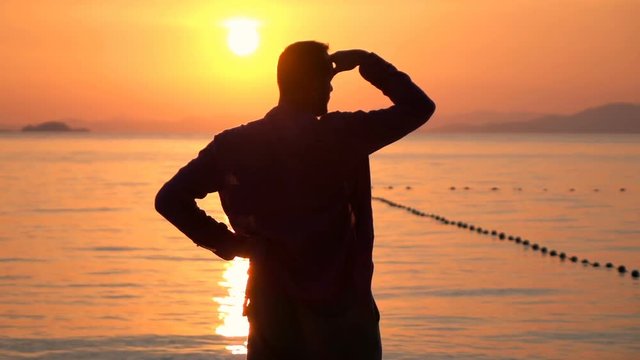 Man enjoying, admire sunset on beach near sea, super slow motion 240fps
