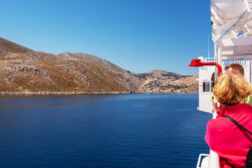 Fototapeta premium A cruise ship with tourists on board approaches the island of Symi. Dodecanese, Greece