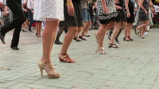 Girls in elegant dresses dancing dance Charleston in the Park. feet close-up