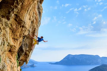 Schilderijen op glas Rock climber on a challenging cliff, extreme sport lifestyle. Travelling Greece © juliet_boo