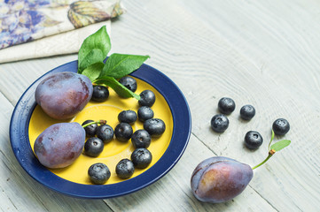 Plums and blueberries in a plate