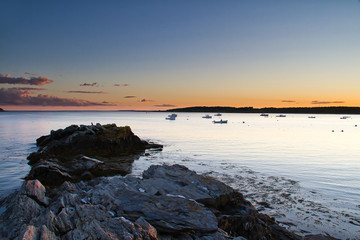 Boats at Sunset Beyond a Rocky Peninsula
