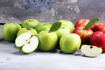 Ripe red apples with leaves on wooden background.