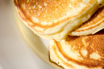 Freshly cooked pancakes on a white ceramic plate.