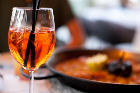 Glass of aperol spritz cocktail long drink close up, summer fresh appetizer, evening meal, dinner
