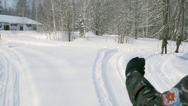 Soldier with weapons in cold forest. Winter warfare and military concept. Clip. Soldiers in winter forest on skis with guns. Military exercises in the forest in slow motion