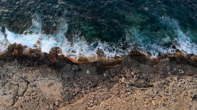 Drone Shot of sea waves washing up on the rocks, shot in Qawra - Malta