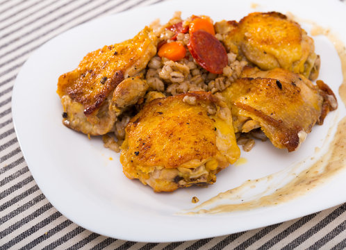 Photography of plate with fried chicken wings with barley porridge