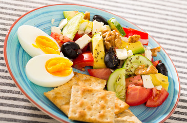 Image of vegetable salad served with boiled egg and cracker