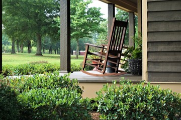 A wooden rocking chair on the beautiful terrace view is waiting for someone to relax on. Ga USA