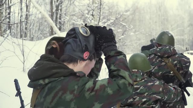 Soldier with weapons in cold forest. Winter warfare and military concept. Clip. Soldiers in winter forest on skis with guns. Military exercises in the forest in slow motion