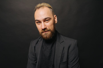 Elegant handsome man in classical suit poses in studio theatre.