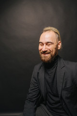 Obraz premium Elegant handsome man in classical suit poses in studio theatre.