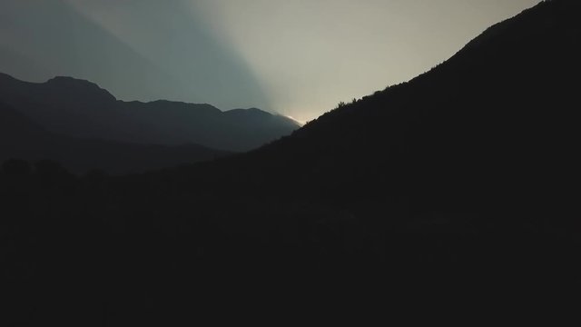 sun hiding behind the hills drone footage