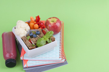 School lunch in the container. Sandwich with cheese and vegetables, fruit and fresh juice. A...