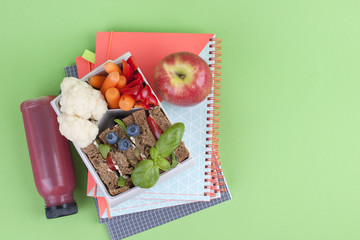 School lunch in the container. Sandwich with cheese and vegetables, fruit and fresh juice. A...